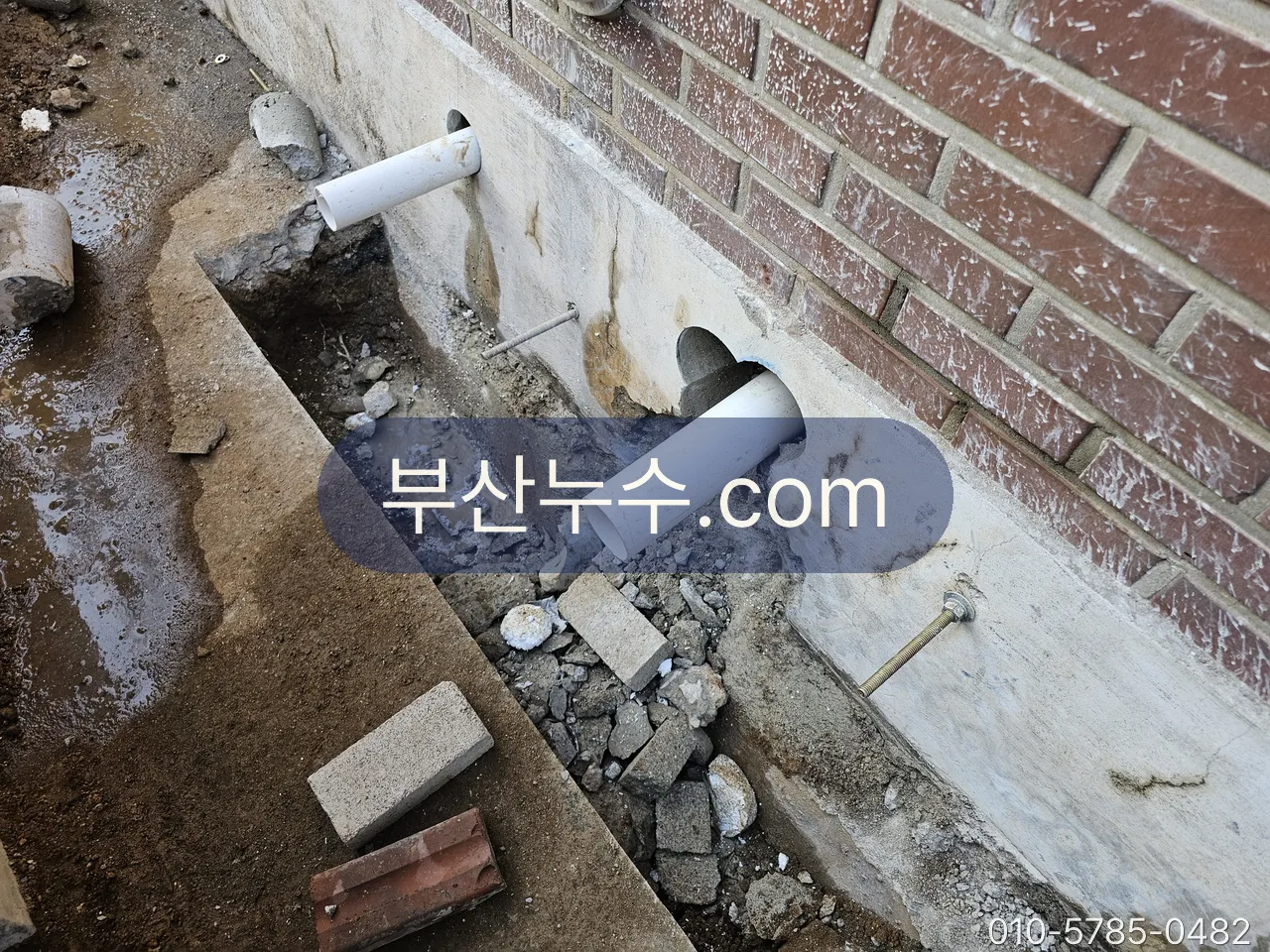 외벽 아래 배관을 드러낸 굴착 현장