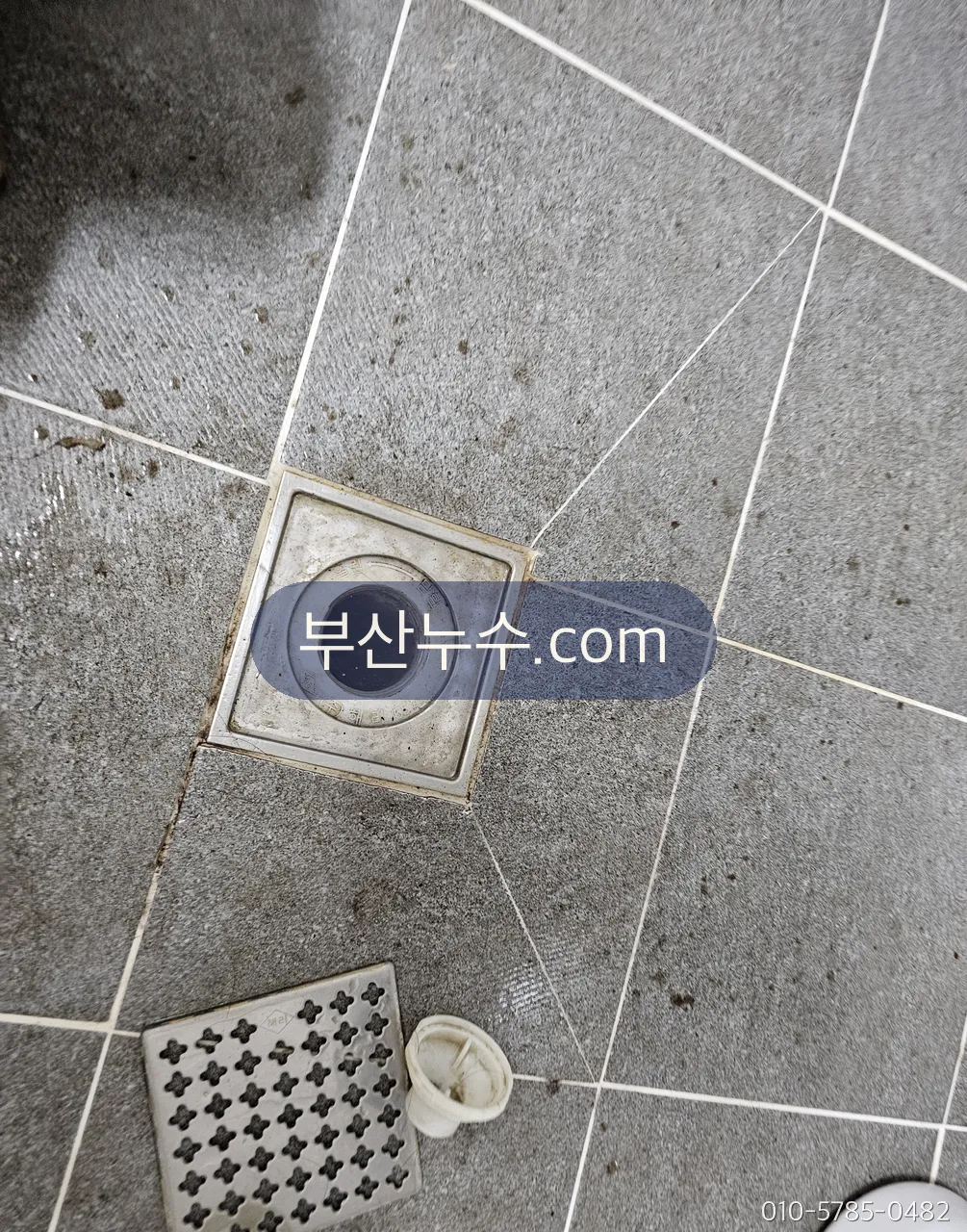 베란다 바닥 배수구 트랩을 분리해 접속 상태를 확인하는 모습