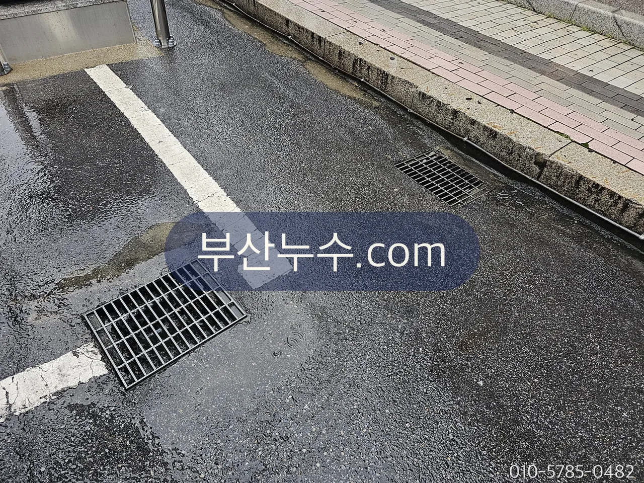 도로 우수받이 격자 둘레로 젖어 있는 바닥