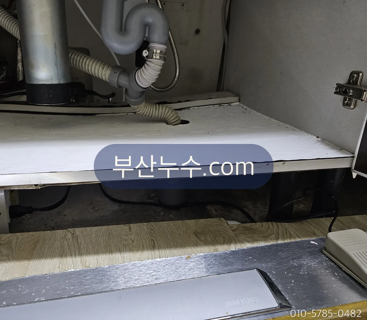 싱크대 하부장 안 배수 트랩과 주름호스 연결부