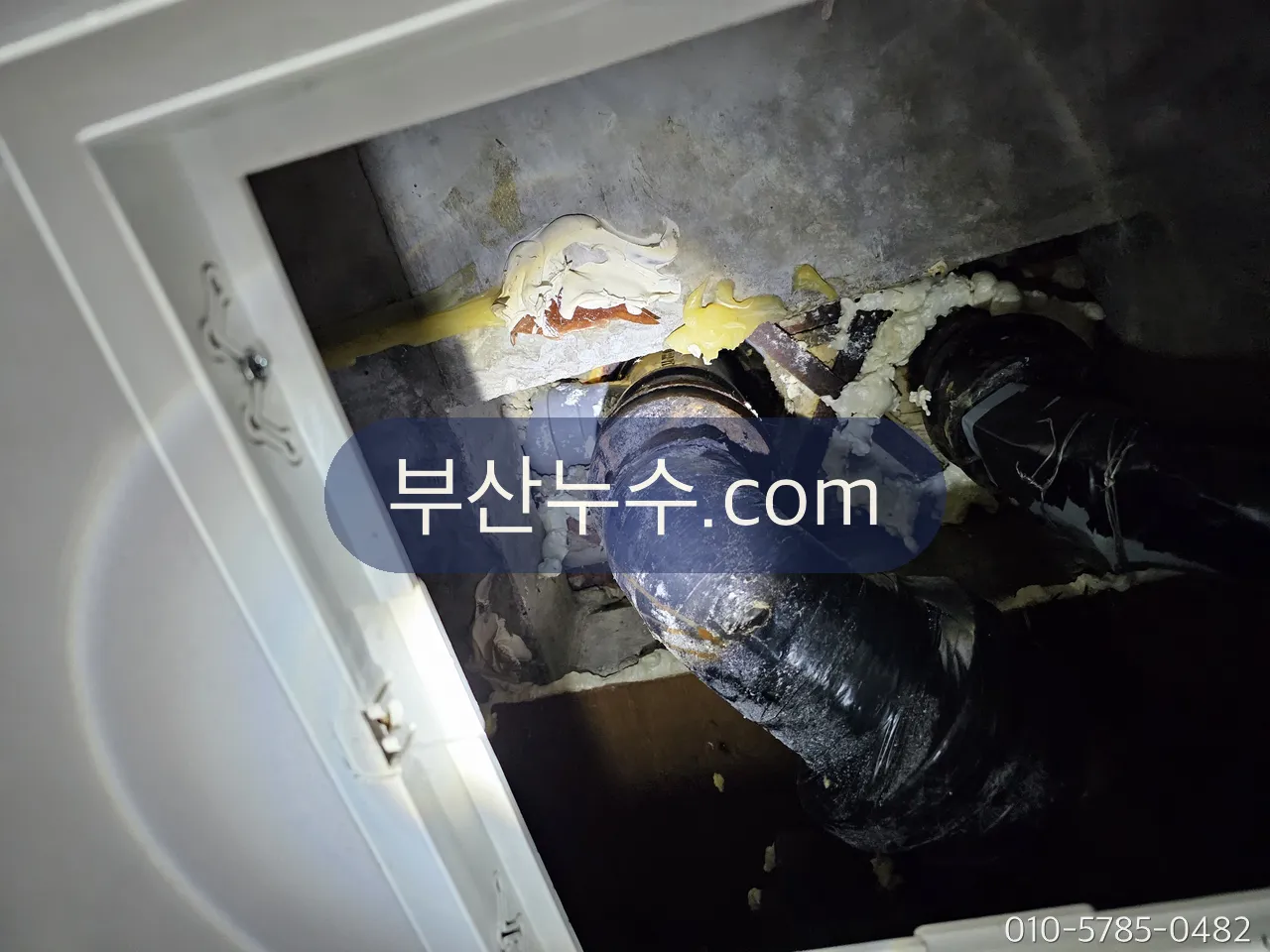 천장 점검구 안으로 위층 배관 하부를 확인하는 모습